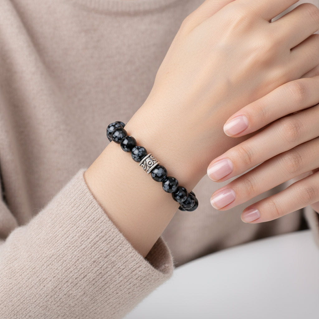 Obsidian Snowflakes bracelet on a wrist with a neutral background